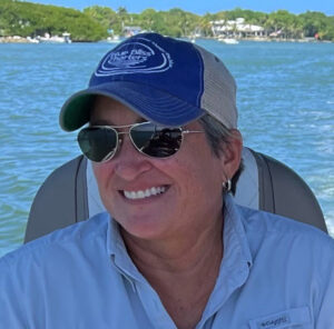 Captain Peggy smiling while driving the pontoon boat