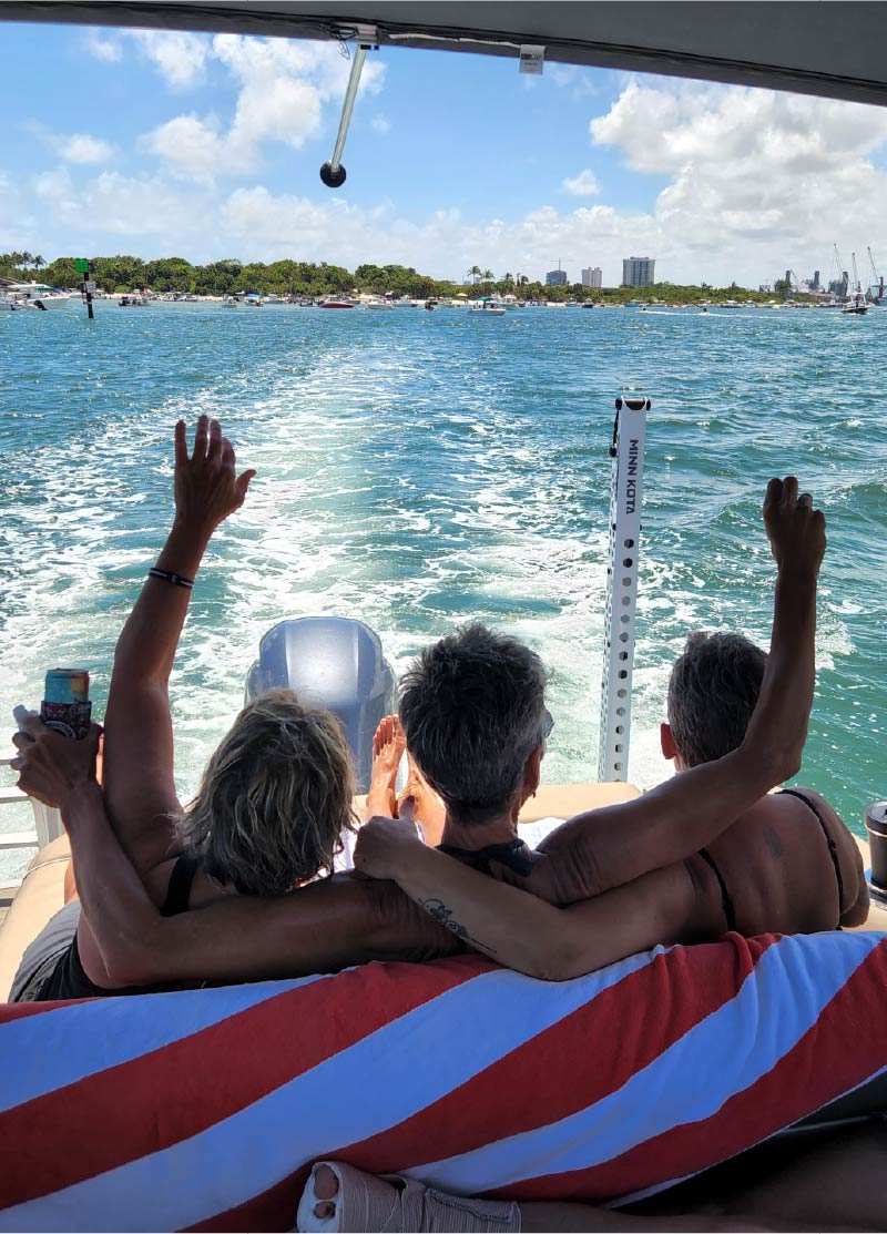 3 ladies sitting on back of pontoon