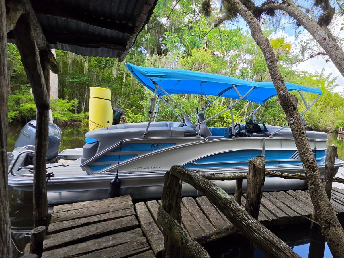 Blue Bliss Charters Bennington tritoon docked along the Loxahatchee River in Jupiter, Florida